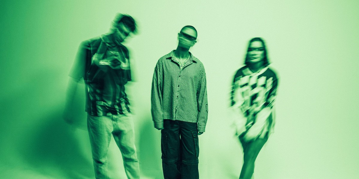 The three members of SNAYX in a green-tinted official press photograph.